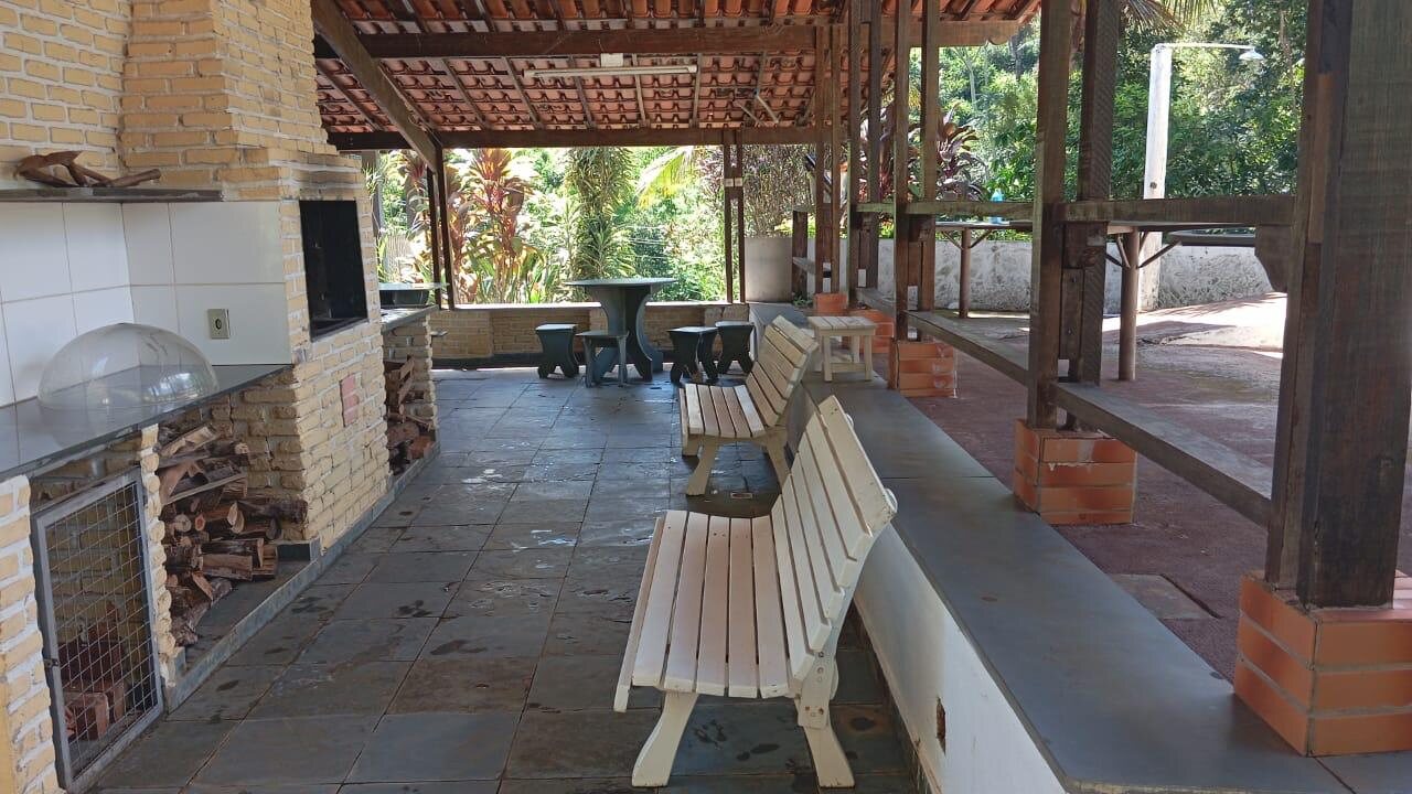 Área gourmet coberta com churrasqueira e bancos